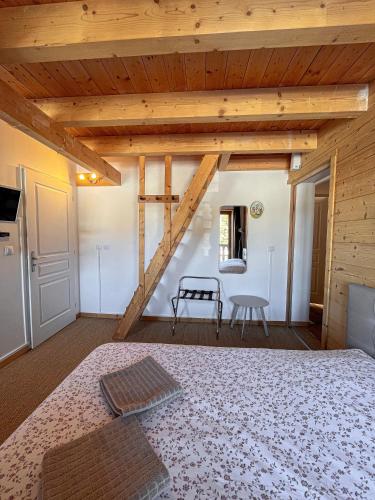 - une chambre avec un grand lit et un plafond en bois dans l'établissement Le Saint Jo - La Féclaz, à Les Déserts