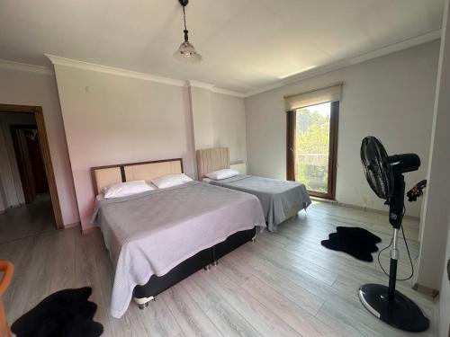 a bedroom with a large bed and a fan at De&Ne apart 2 in Rize