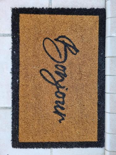 un tapis avec une aigraphie dessus sur un mur dans l'établissement Maison sur la place du marché à St Chinian, à Saint-Chinian