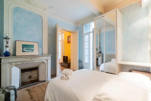 - une chambre avec un lit blanc et une cheminée dans l'établissement L'Authentique, à Montpellier