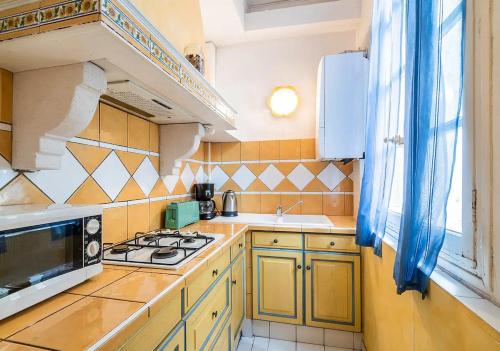 une petite cuisine avec une cuisinière et un micro-ondes dans l'établissement L'Authentique, à Montpellier