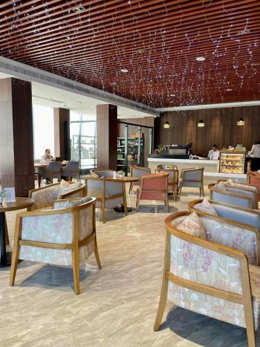a lobby with chairs and tables and a restaurant at Keis Place Tagaytay in Tagaytay