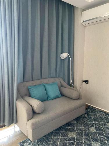 a couch with two blue pillows in a living room at Keis Place Tagaytay in Tagaytay