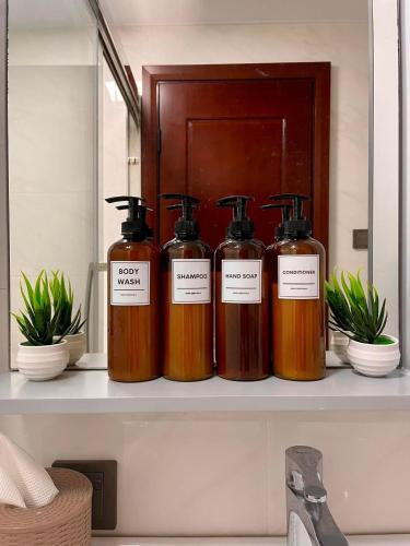 four bottles of soap on a shelf in a bathroom at Keis Place Tagaytay in Tagaytay