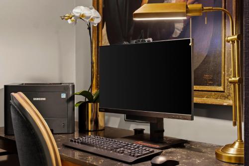 monitor komputerowy i klawiatura na biurku z lampą w obiekcie Inn at the Opera w mieście San Francisco