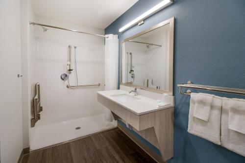 W łazience znajduje się biała umywalka i lustro. w obiekcie WoodSpring Suites Winston-Salem near Hanes Mall w mieście Winston-Salem