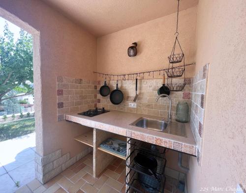 une cuisine avec un évier et un comptoir avec des casseroles et des poêles dans l'établissement Holiday home "225 Marc Chagall", à Mandelieu-la-Napoule