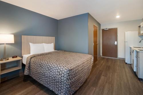 pokój hotelowy z łóżkiem i kuchnią w obiekcie WoodSpring Suites Winston-Salem near Hanes Mall w mieście Winston-Salem