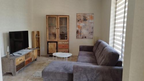 Una sala de estar con un sofá y un televisor de pantalla plana. en Aphrodite Park, en Sunny Beach