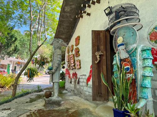 a house with a statue next to a door at Clay House Chiang Mai By Alphatel in Chiang Mai