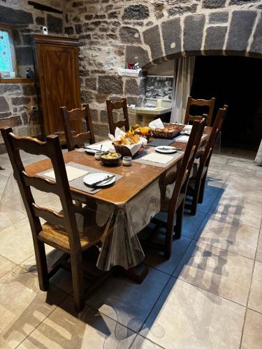 een houten tafel met stoelen en eten erop bij Le Pigeonnier de Lissac in Lissac-sur-Couze