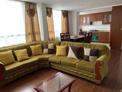 sala de estar con sofá verde y mesa en Instant Hotel - Villa Palermo Luxury Apartments en Ambato