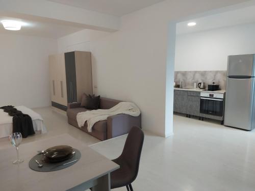 uma sala de estar com uma mesa e uma cozinha em Villa Romelia - Select Apartments em Vadu