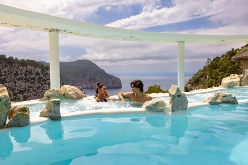 a woman and her dog in a infinity pool at a resort at Hacienda Na Xamena, Ibiza in Na Xamena