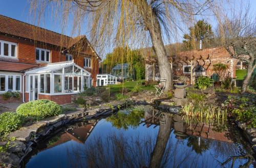 a house with a pond in front of a house at The Garden Studio Woodcombe in Minehead