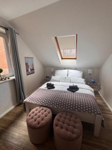 a bedroom with a large bed with two ottomans at Altstadtferienwohnung Stade-Cozy Home -ein zweites Zuhause finden in Stade