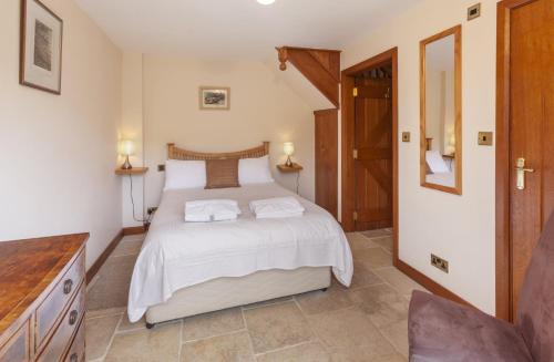 Un dormitorio con una cama con dos toallas encima. en The Granary, en Luxborough