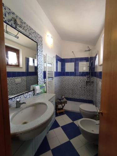 a bathroom with a sink and a toilet and a mirror at Appartamento Silvana Terme in Rapolano Terme