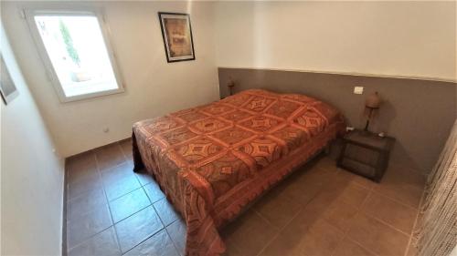 un petit lit dans une chambre avec une fenêtre dans l'établissement Logement indépendant, piscine, pool-house et terrasse privés, à Castelnau-de-Guers