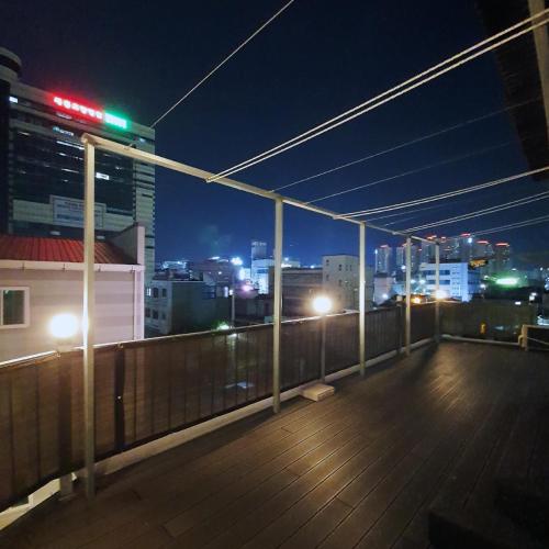 a rooftop deck with a view of a city at night at Ariene Guesthouse in Gwangju