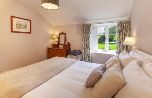 a bedroom with a large bed and a window at Stockham Farm, Dulverton in Dulverton