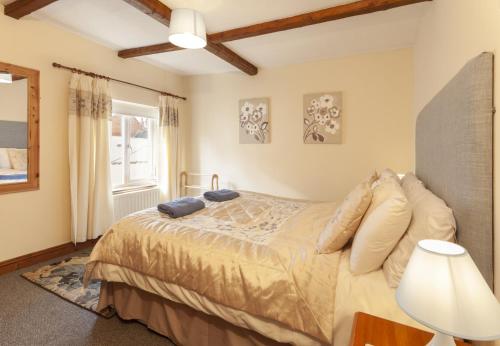 a bedroom with a bed and a window at Cuain Cottage, Watchet in Watchet