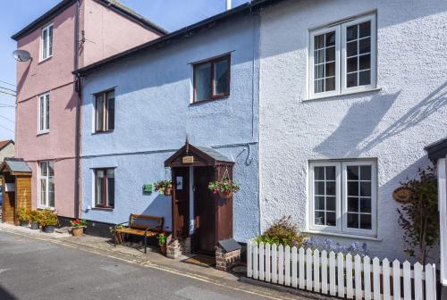 a blue and white house with a white fence at Cuain Cottage Watchet in Watchet