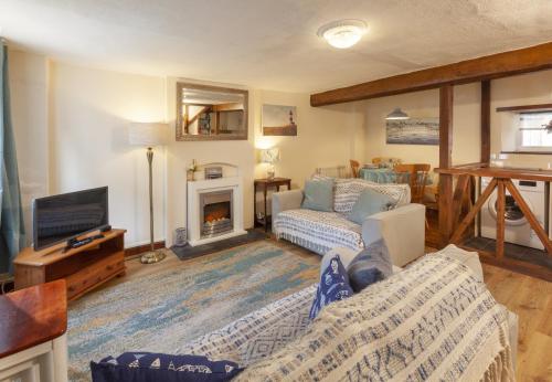 a living room with a couch and a fireplace at Cuain Cottage Watchet in Watchet