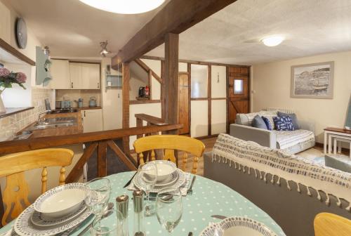 a dining room with a table and chairs and a kitchen at Cuain Cottage Watchet in Watchet