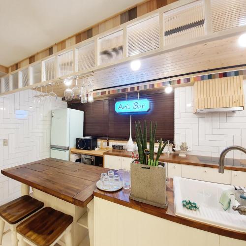 a kitchen with a table and a sign on the wall at Ariene Guesthouse in Gwangju
