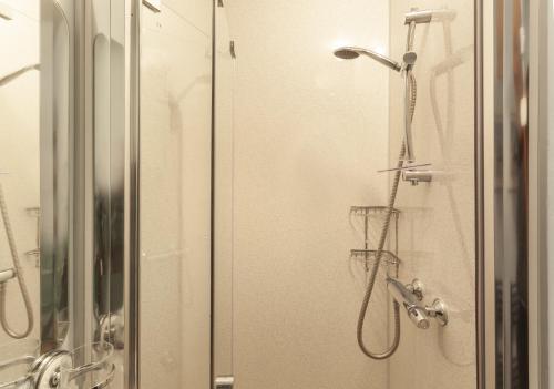 a shower in a bathroom with a glass door at Cuain Cottage, Watchet in Watchet