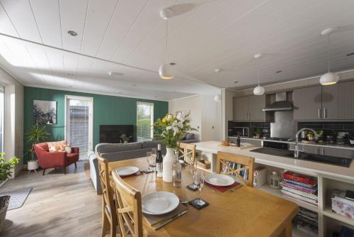 a kitchen and dining room with a table and chairs at Cedar Lodge, Strawberryfield Park in Cheddar