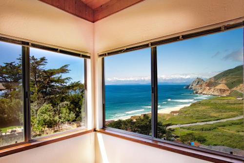 a room with windows looking out at the ocean at Stunning Oceanview Coastal Home Beach Trails Family Activities in Montara