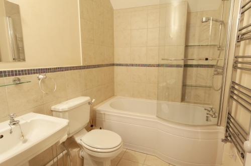 a bathroom with a toilet and a tub and a sink at Lorna Doone Cottage, Lynmouth in Lynmouth