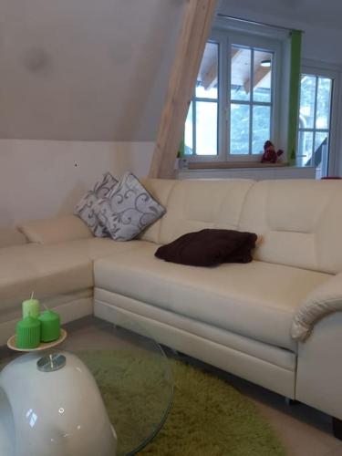 a living room with a white couch and a table at Fichtenloft in Heinersdorf
