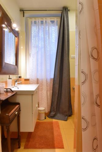 a bathroom with a sink and a shower curtain at Ventitrémarzo Guest House in Novara