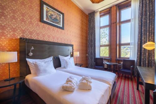 a hotel room with two beds with shoes on them at Grand Hotel Amrâth Amsterdam in Amsterdam