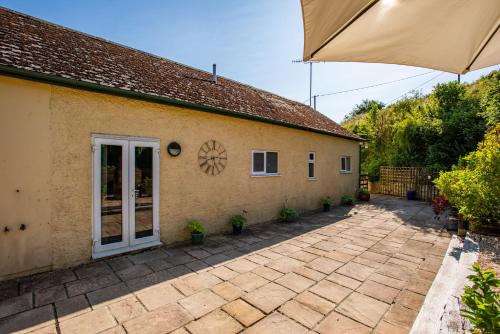 a house with a patio and an umbrella at The Old Laundry, Exford in Exford