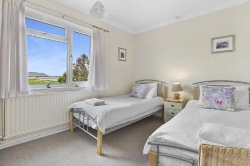 a bedroom with two beds and a window at Meadow View, Blue Anchor in Blue Anchor