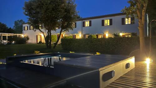 a swimming pool in front of a building at night at Agromarino in Sirolo