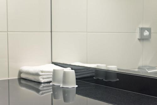 a bathroom with a mirror and a pile of towels at Maritim Hotel Bellevue Kiel in Kiel