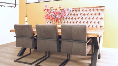 a wooden table with two chairs and a vase of flowers at Luxe woning Bubbles! Met airco en Parkeren op eigen grond in Castricum