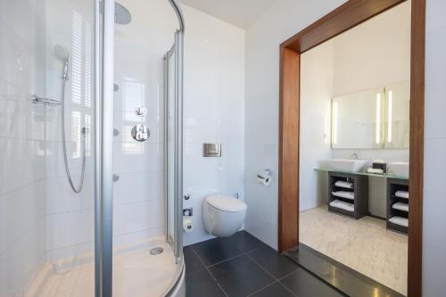 a bathroom with a shower and a toilet and a sink at Grand Hotel Amrâth Amsterdam in Amsterdam