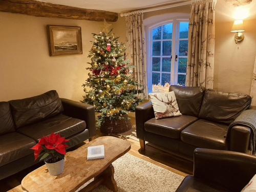 a living room with a christmas tree and a couch at The Piggery, Dulverton in Dulverton