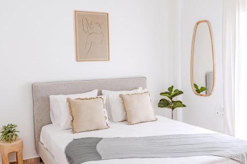 a bedroom with a bed with white sheets and pillows at The Yard Residence in Gavalochori