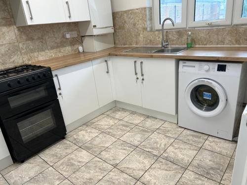 a kitchen with a washing machine and a sink at London City Inn Stepney in London