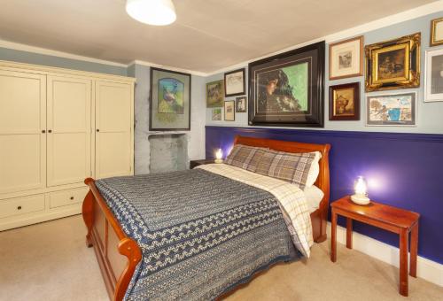 a bedroom with a bed and a purple wall at Grist Mill, Dunster in Dunster