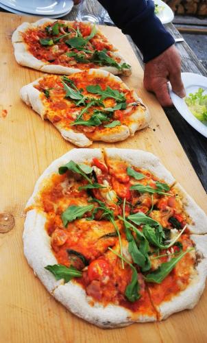 three pizzas sitting on top of a wooden table at Wieserhof Tirol in Oetz