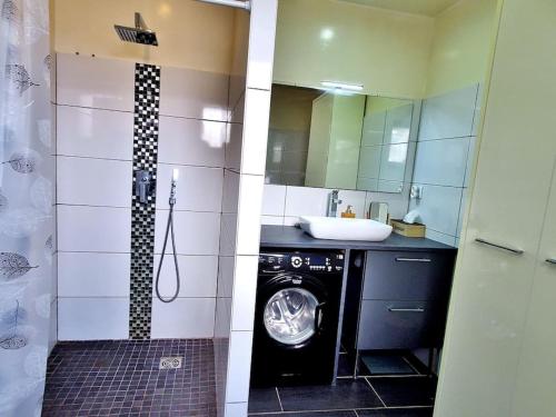 une salle de bain avec une machine à laver et un lavabo dans l'établissement O' bien-être provençal, à Le Rove