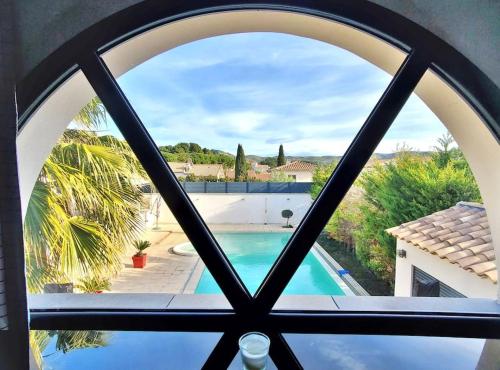 Elle offre une vue sur la piscine depuis sa fenêtre. dans l'établissement O' bien-être provençal, à Le Rove